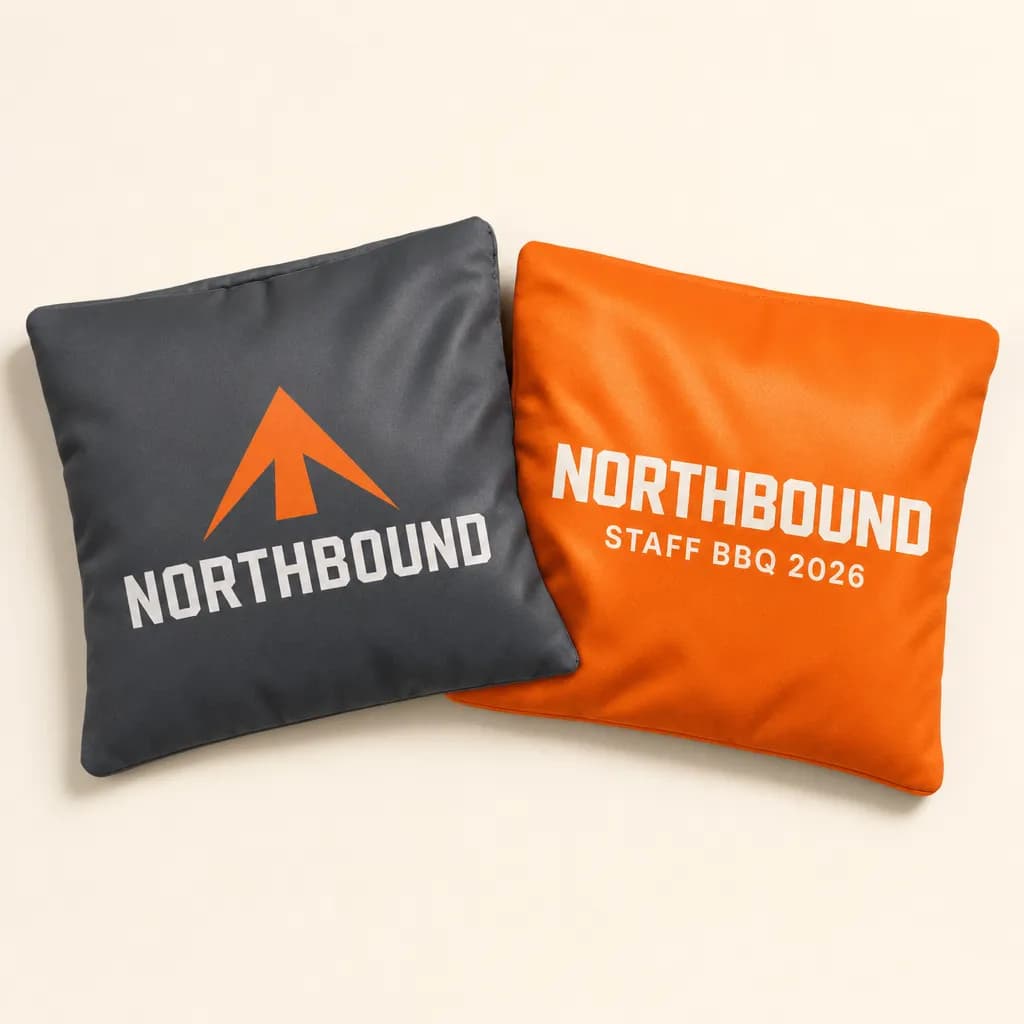 Charcoal and orange cornhole bags printed with a company logo